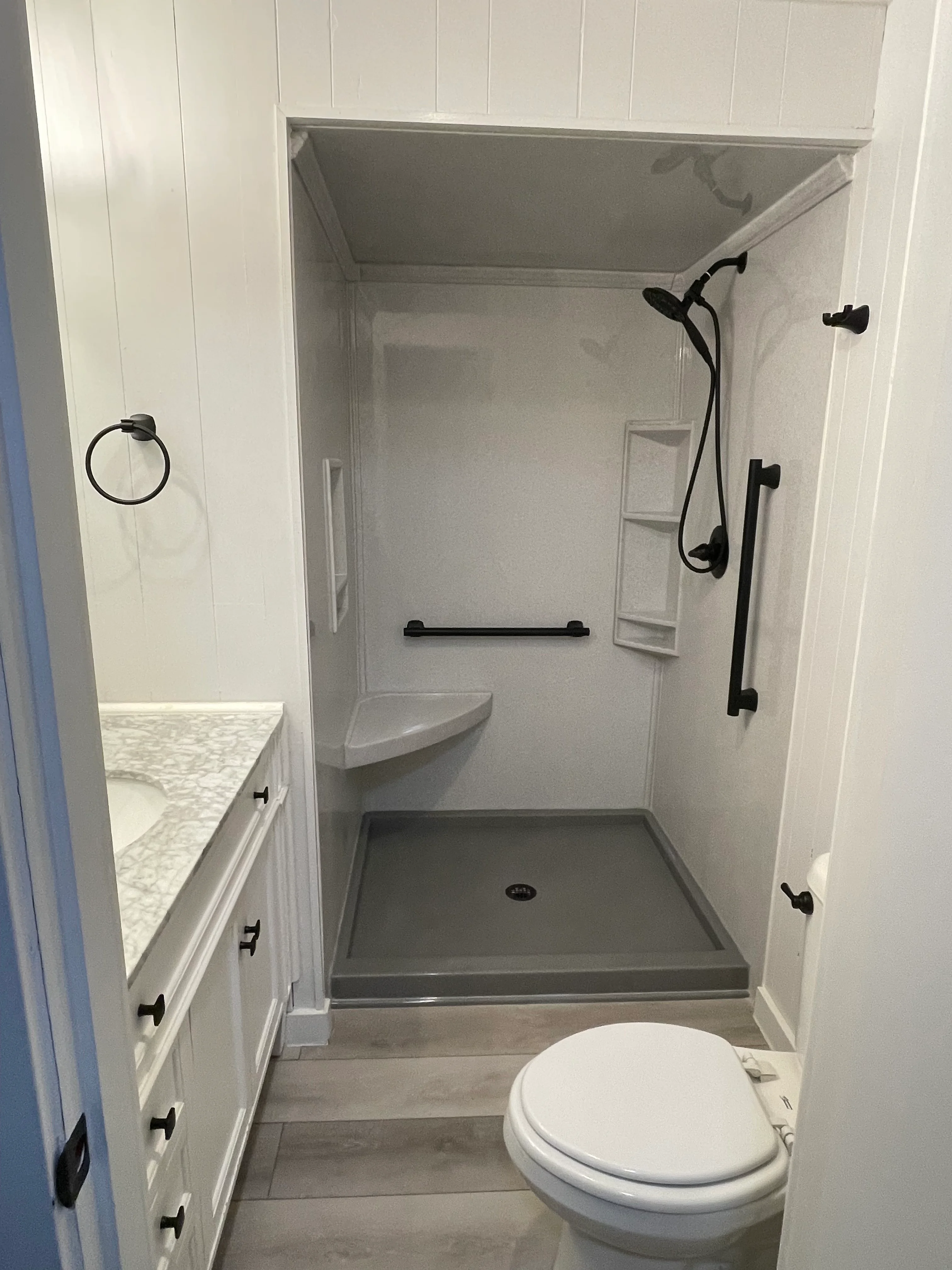 Newly installed water-resistant tile bathroom floor in a Tacoma home, showing clean grout lines, sealed edges, and a smooth transition to the bathroom doorway threshold.